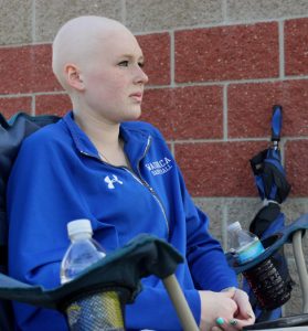 Taylor Vaughn watches her brother Justin play in a junior varsity baseball game at Waupaca High School in May. She is currently undergoing chemotherapy treatment for Burkitt's lymphoma.  Greg Seubert Photo