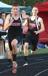 Manawa's Sam Welch takes the baton from Daniel Teuscher in the boys' 800-meter relay at the Rosholt Regional. Welch, Teuscher, Ethan Hass and Trenton Saunders finished third and will compete at state. The relay team's time of 1:33.18 also broke the school record.  Holly Neumann Photo