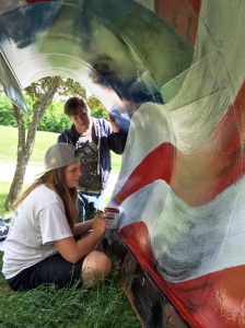 Painting the U.S. flag on a plow are (from left) Brittany Besaw and Sebastain Mikkelson. Submitted Photo
