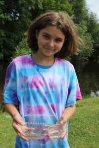 Aaliyah Close shows what she scooped from the Waupaca River into a plastic tray during a visit to Riverview Park as part of the new After Summer School Adventure Program. Angie Landsverk Photo