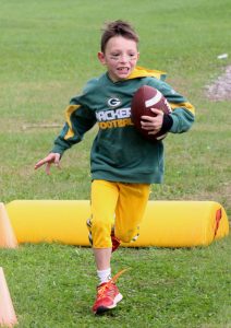 Weyauwega Elementary School third-grader Evan Graham winds his way through an obstacle course while carrying a football. Greg Seubert Photo