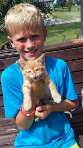 Parker Wilson holds the kitten his family named "Sunny" after it showed up at their home last summer. Submitted Photo