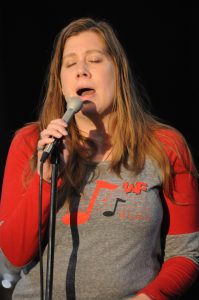 Molly Stillwell singing at microphone