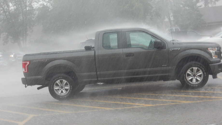 Vehicles get covered by driving rain in a parking lot. Submitted photo